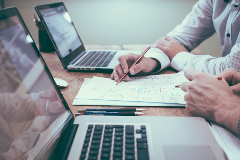 Two professionals reviewing financial documents and audit paperwork