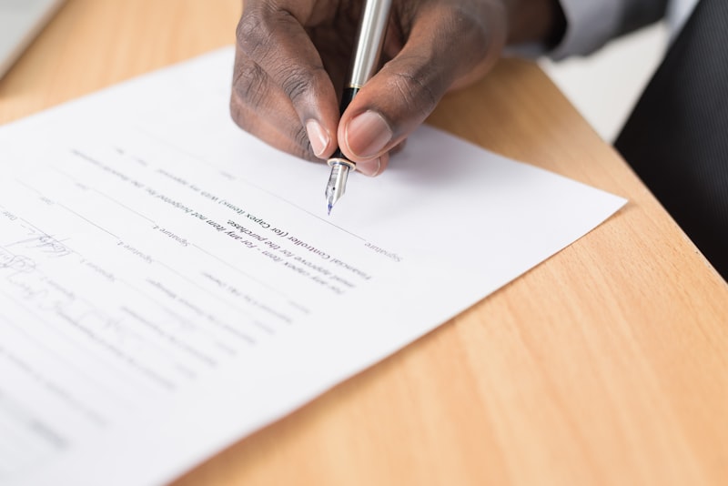 Professional signing a formal registration document at an executive desk